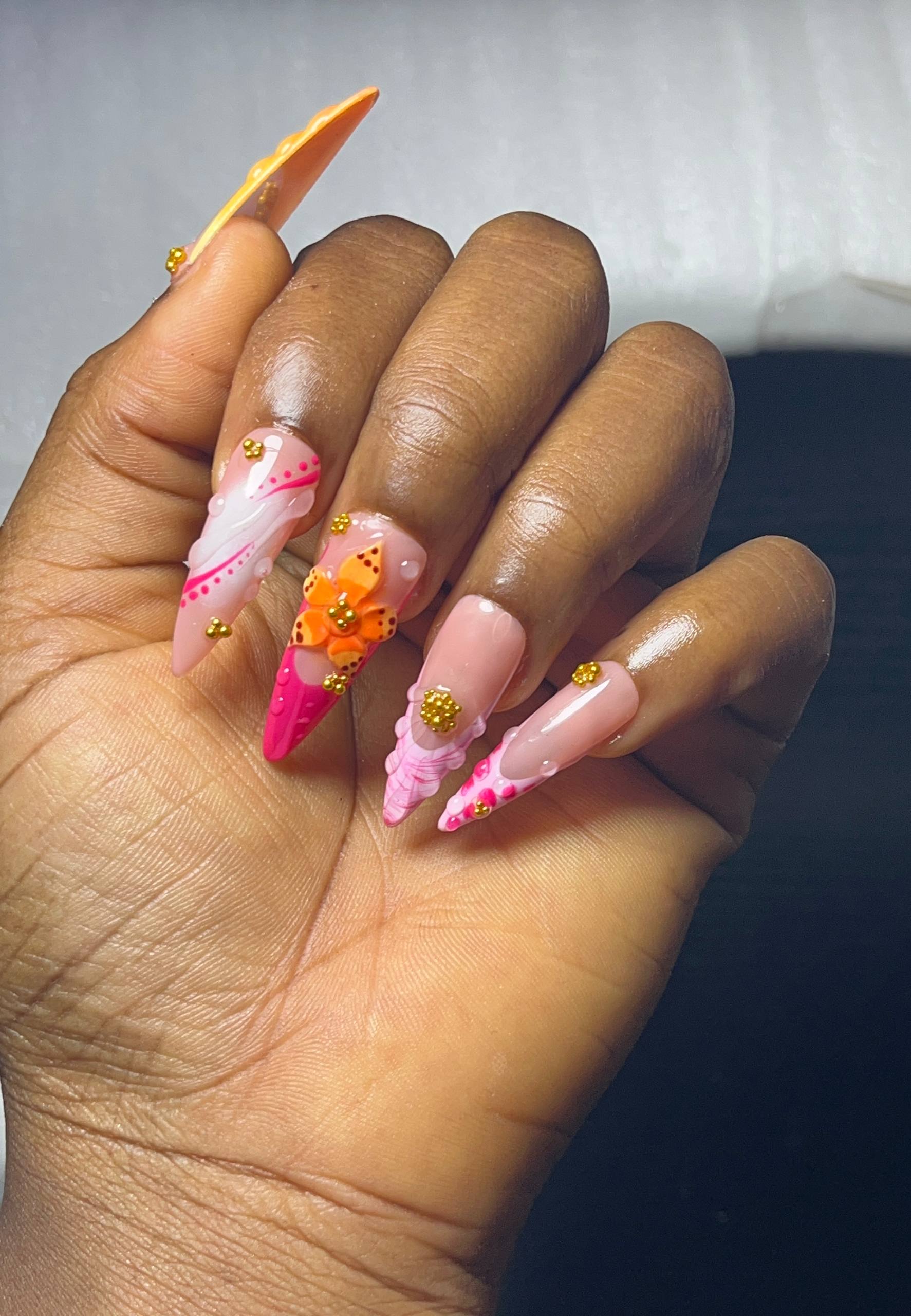 Nail art by Zoba Beauty β pink and orange stiletto set with 3D flower and gold accents